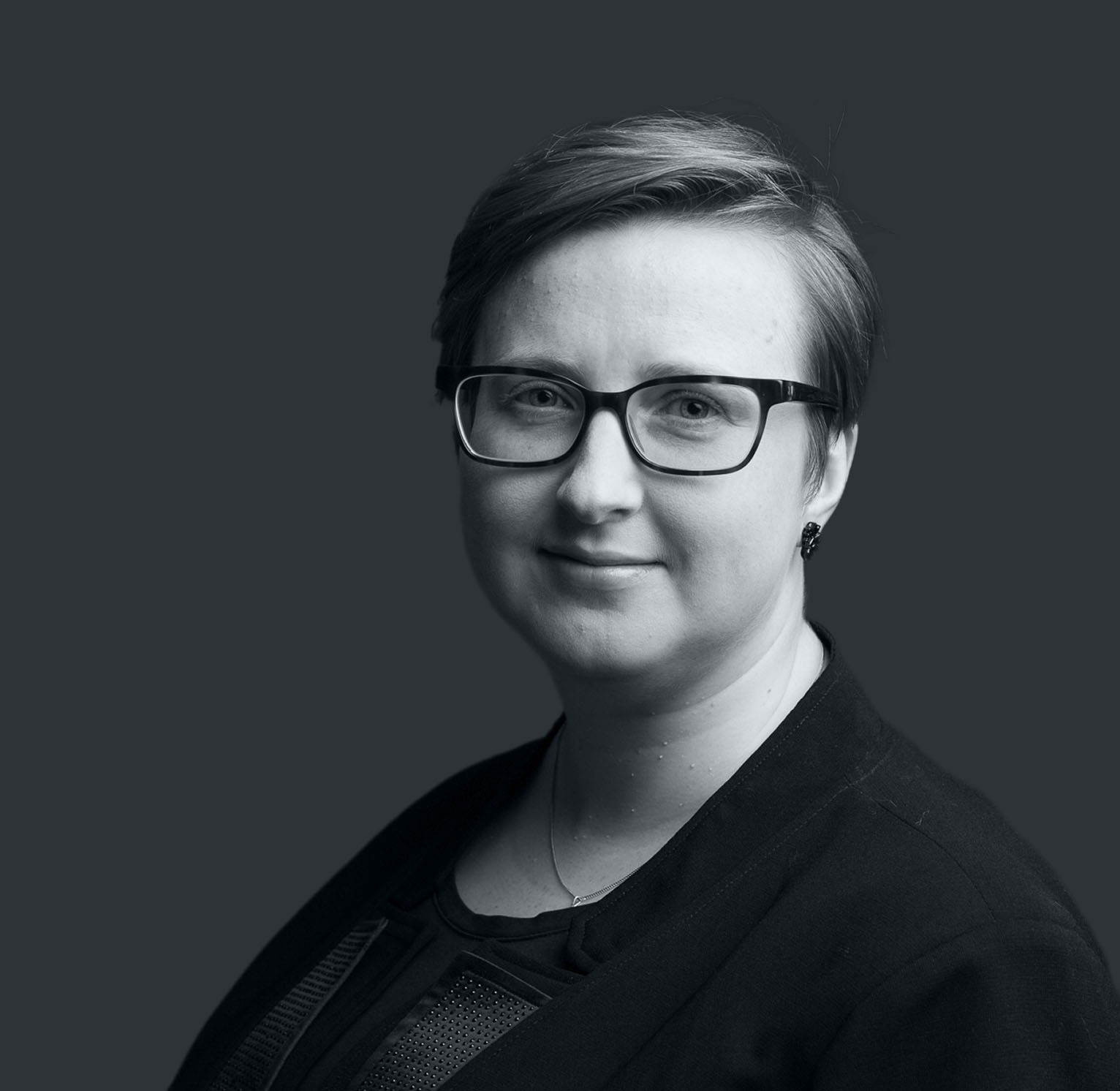 Autorka strony – uśmiechnięta kobieta w okularach, w formalnym stroju